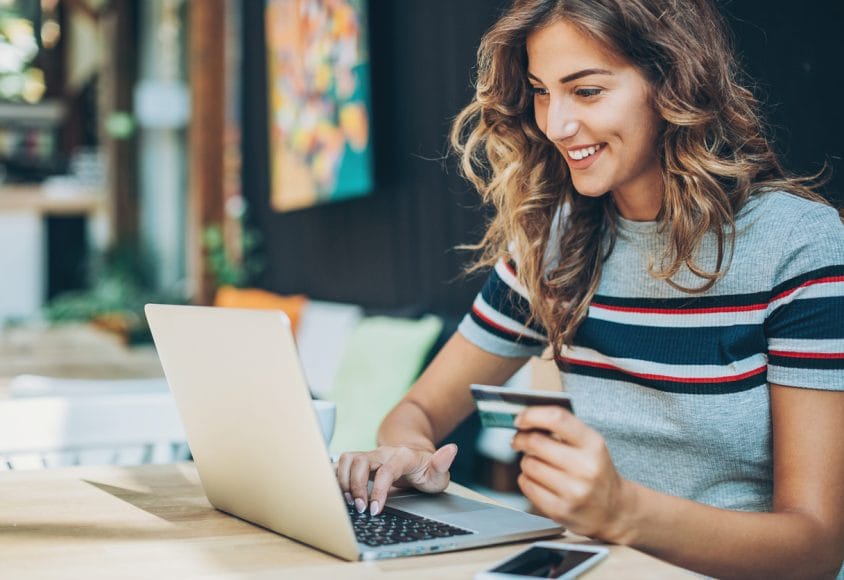 Kobieta przy laptopie z kartą kredytową.